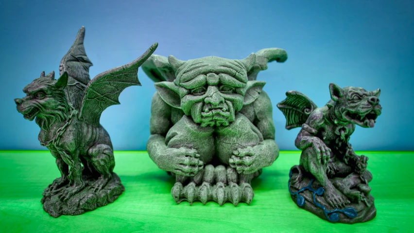 a group of three statues of animals with horns and claws