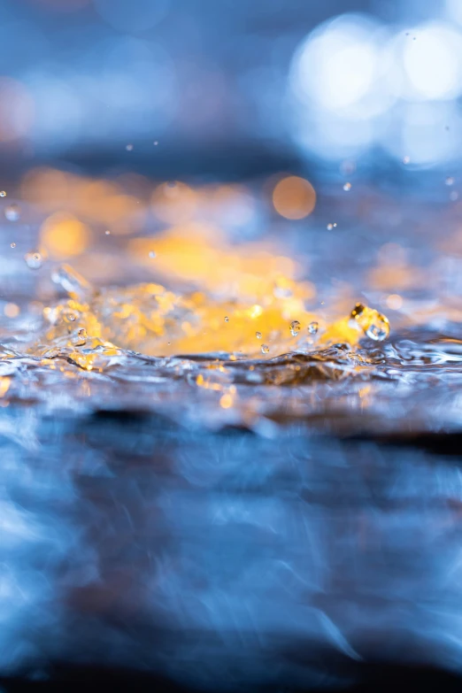 yellow droplet splashing on blue water, viewed from above