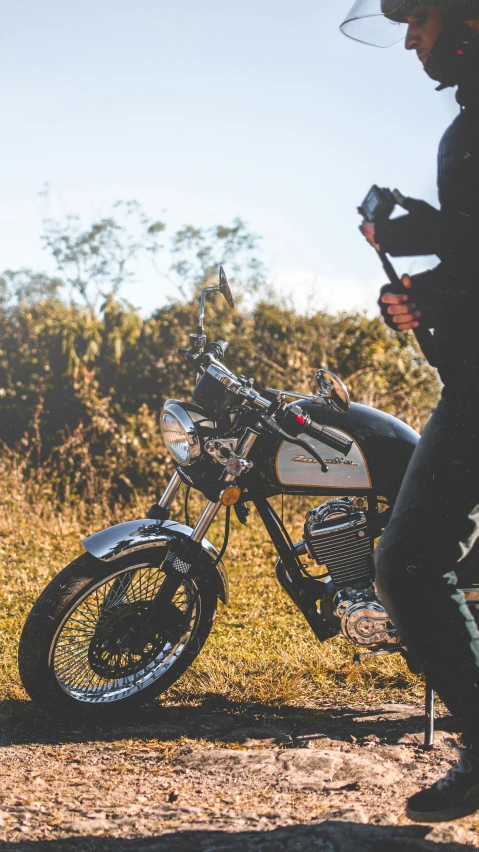 a person holding an umbrella next to their motorcycle