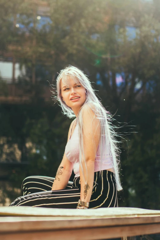 the girl with tattoos is sitting on a table