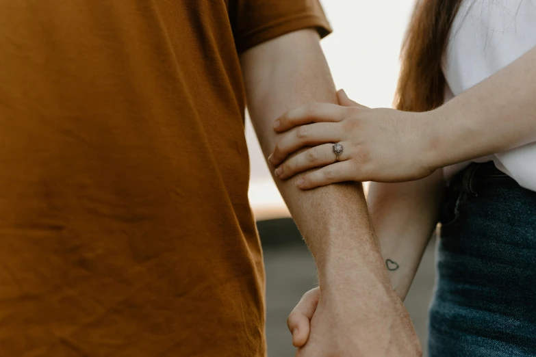 a close up of two people holding hands