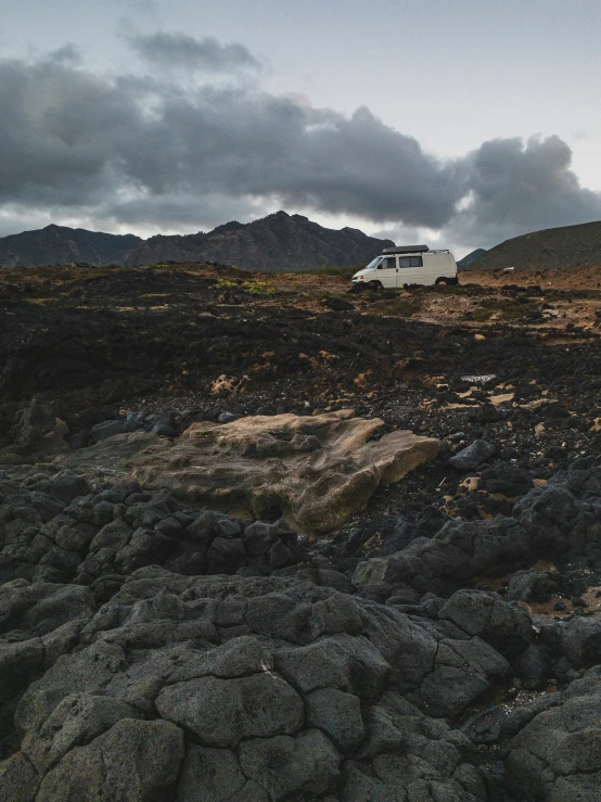 there is a small white truck that is parked on the mountain