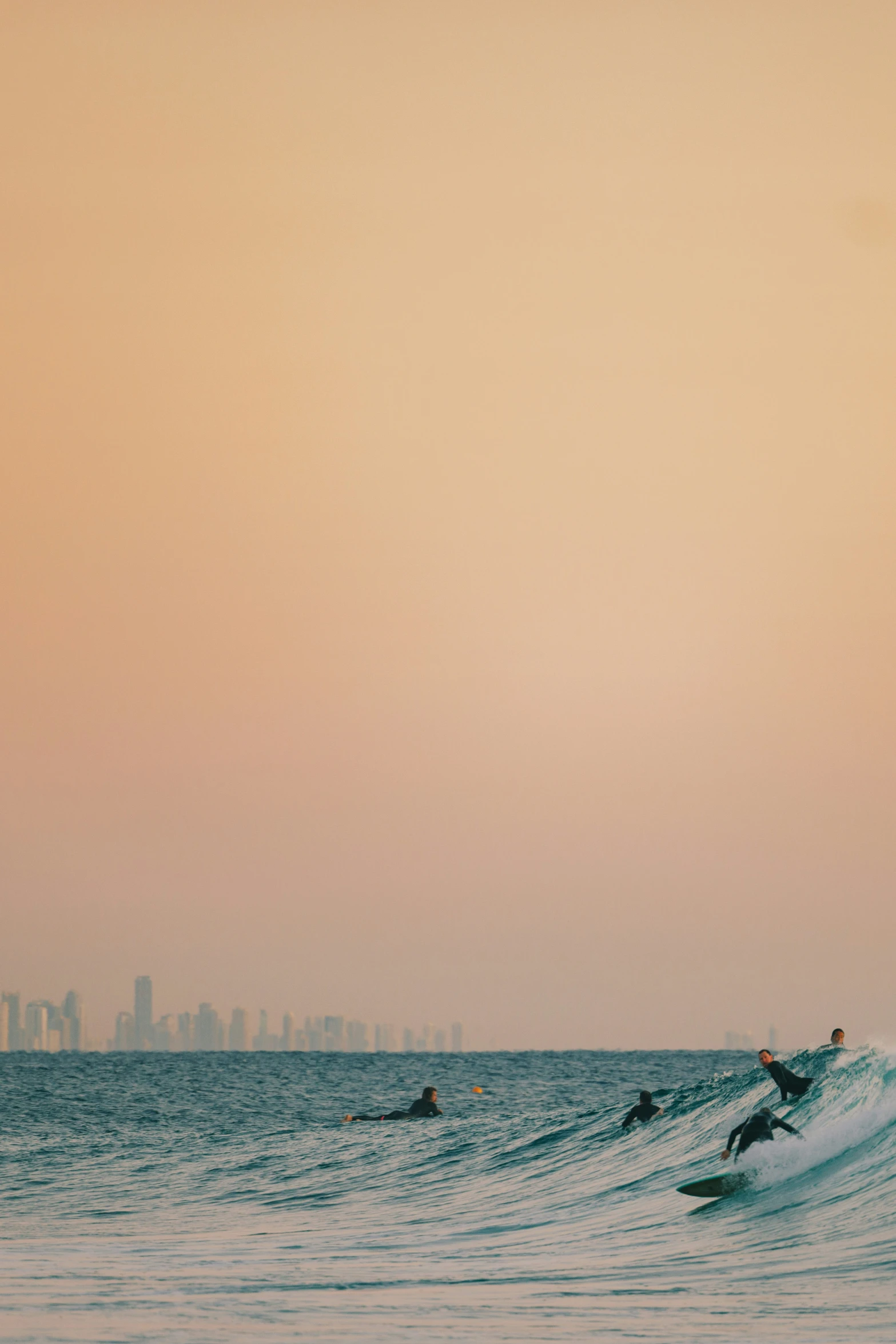 two surfers riding the waves in the ocean near the city