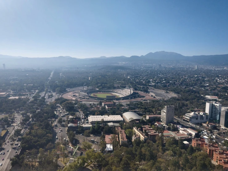 an aerial view of city and surrounding park area with mountains