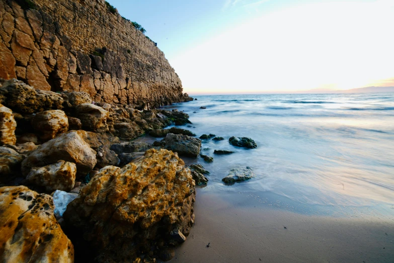 rocks and seaweed along the beach on a sunny day