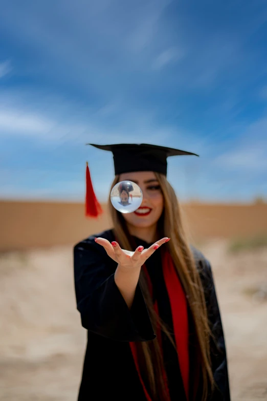 a woman is holding her graduation cap out