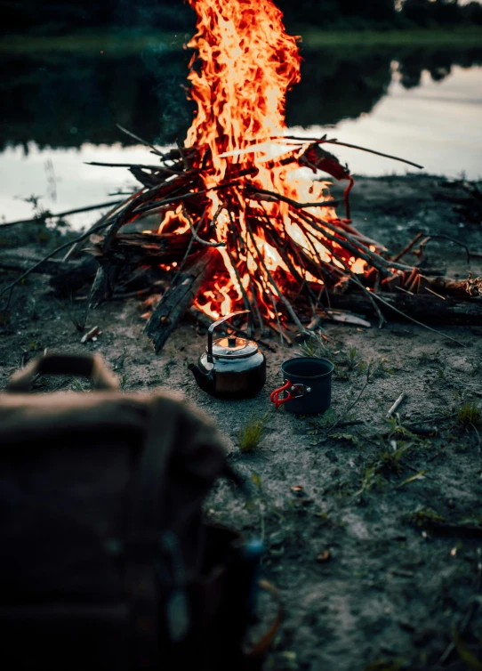 a fire and some camp stove near water