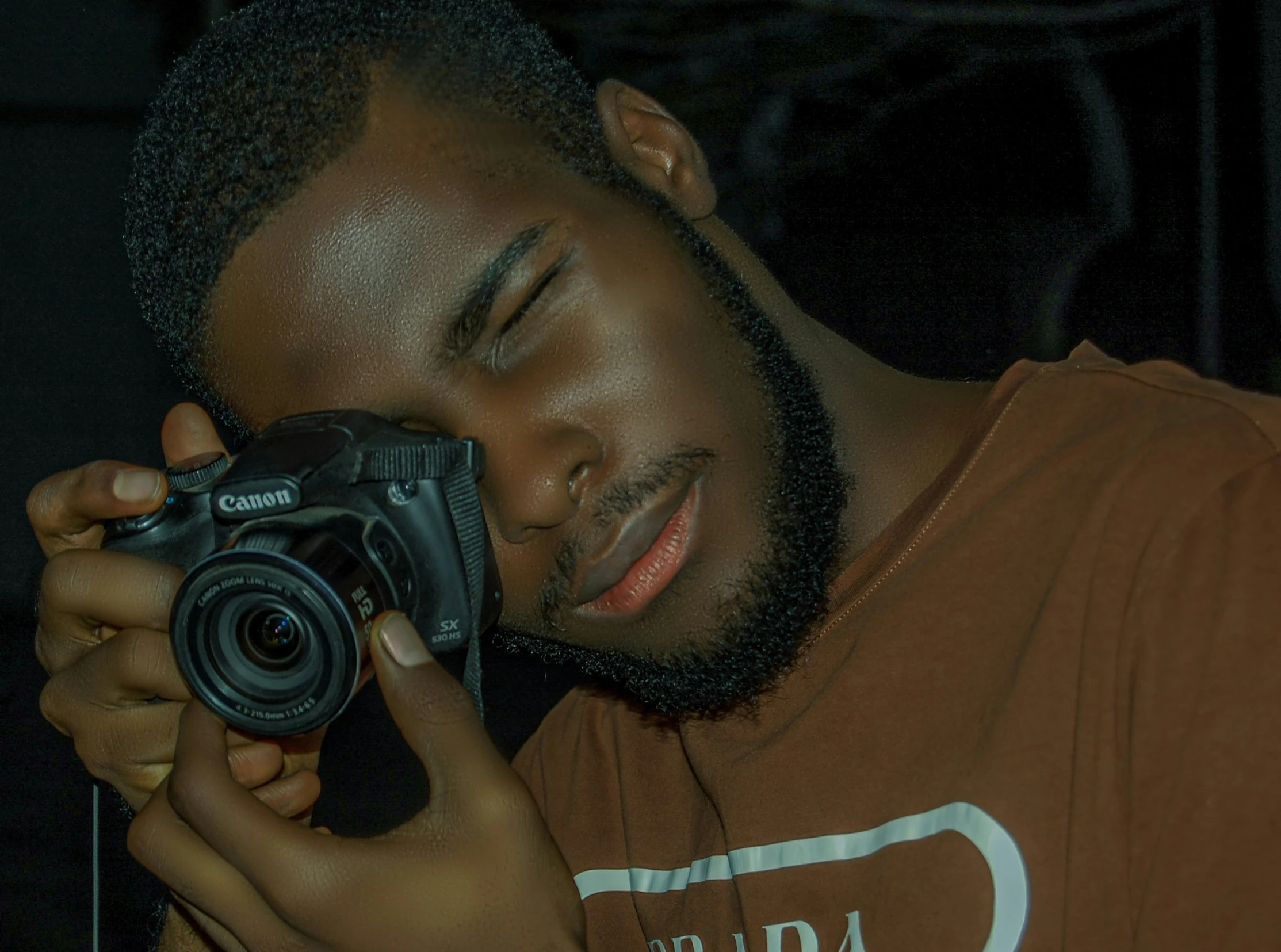 man holding camera looking into the distance taking a picture