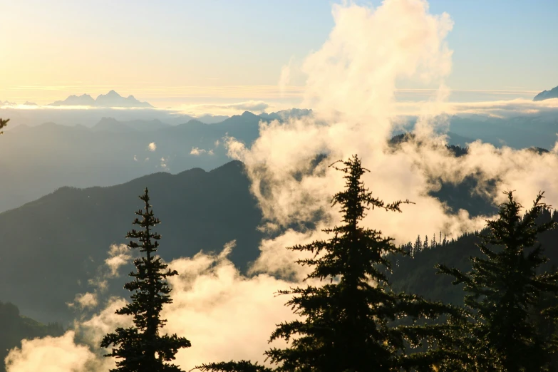 an area with trees, clouds and mountains