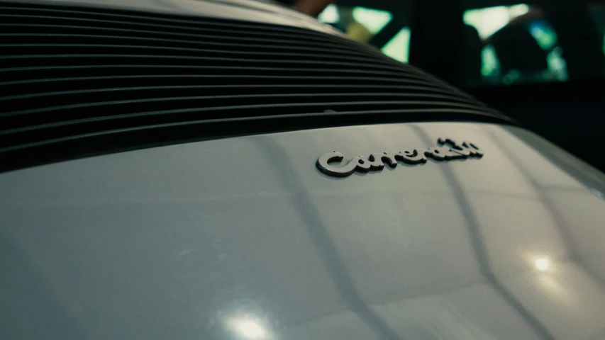 the name of a silver car with a small black word on the hood