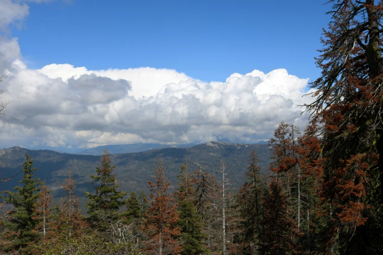 the mountains covered with snow are seen against blue sky and clouds