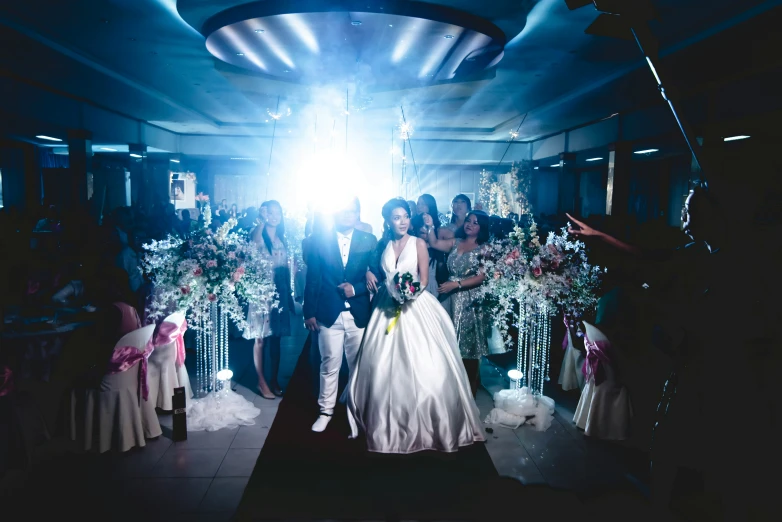 a couple in wedding attire walking towards the exitway with their arms around each other