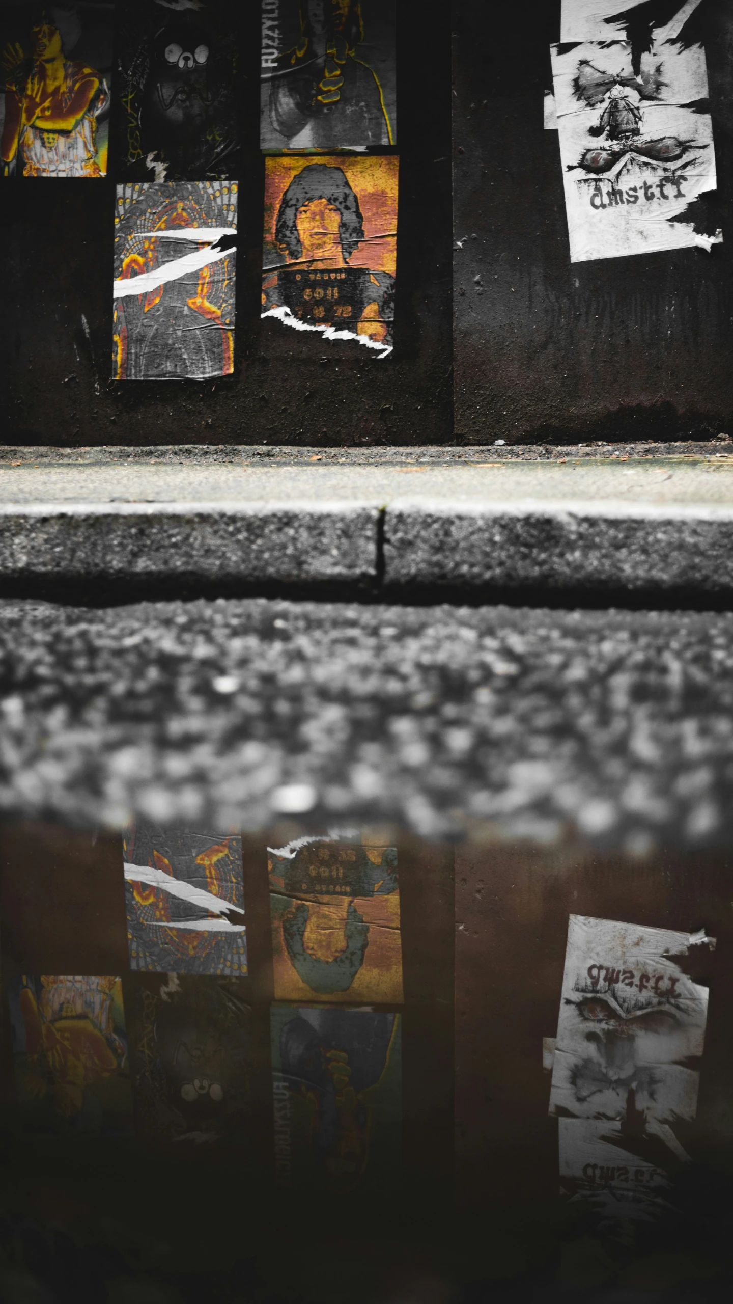 a sidewalk in front of a building with torn up posters hanging on it