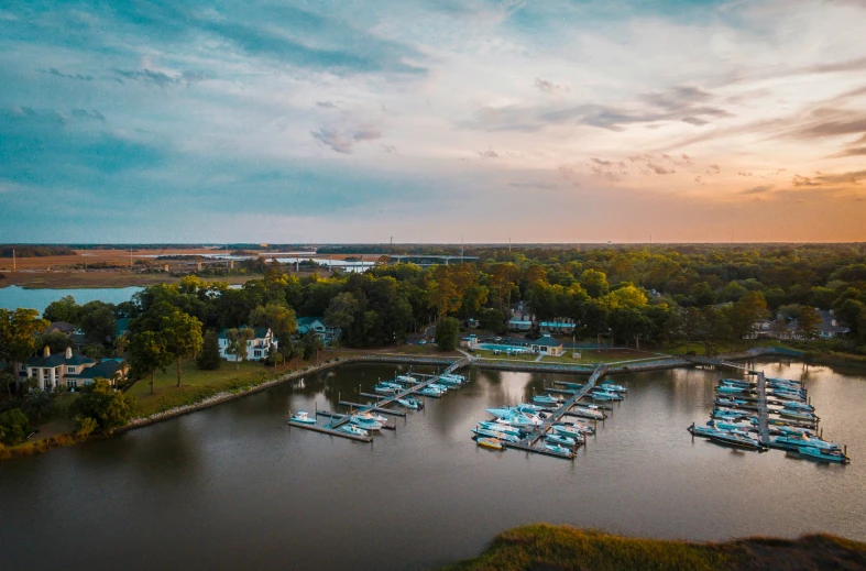 an aerial view of boats on the water at sunset