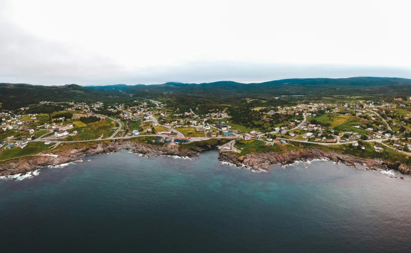 an aerial view of a residential area and a waterfront in the foreground