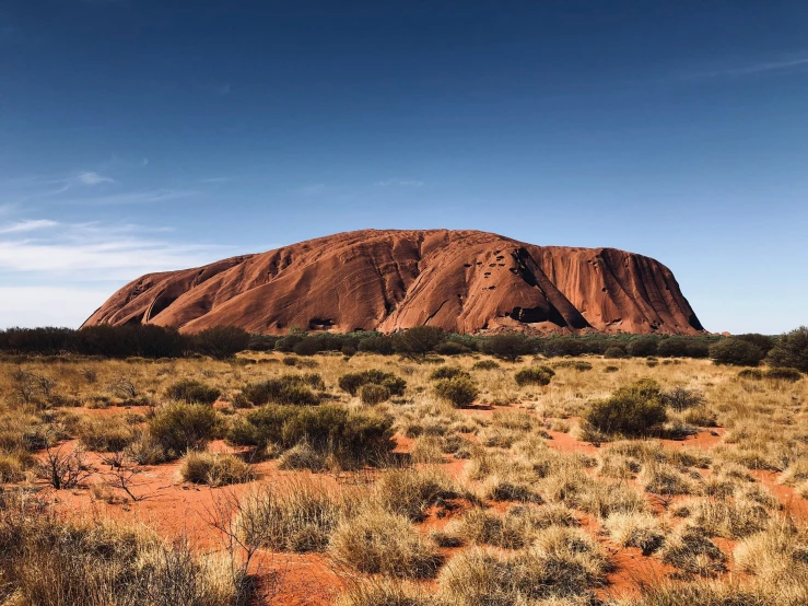 a large hill sits behind an arid terrain