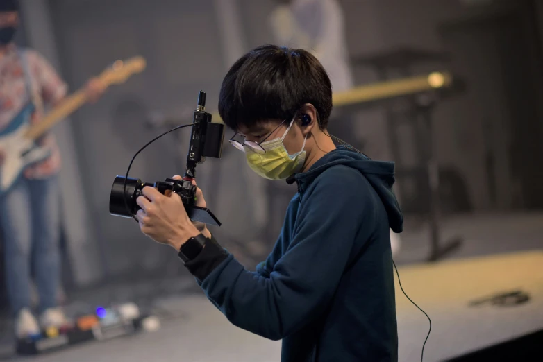 a man standing with a video camera in front of his