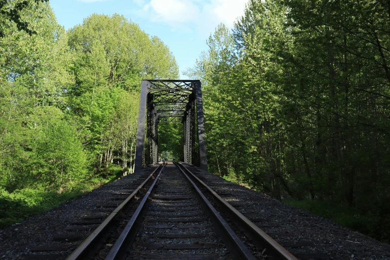 an old train bridge sitting over a river