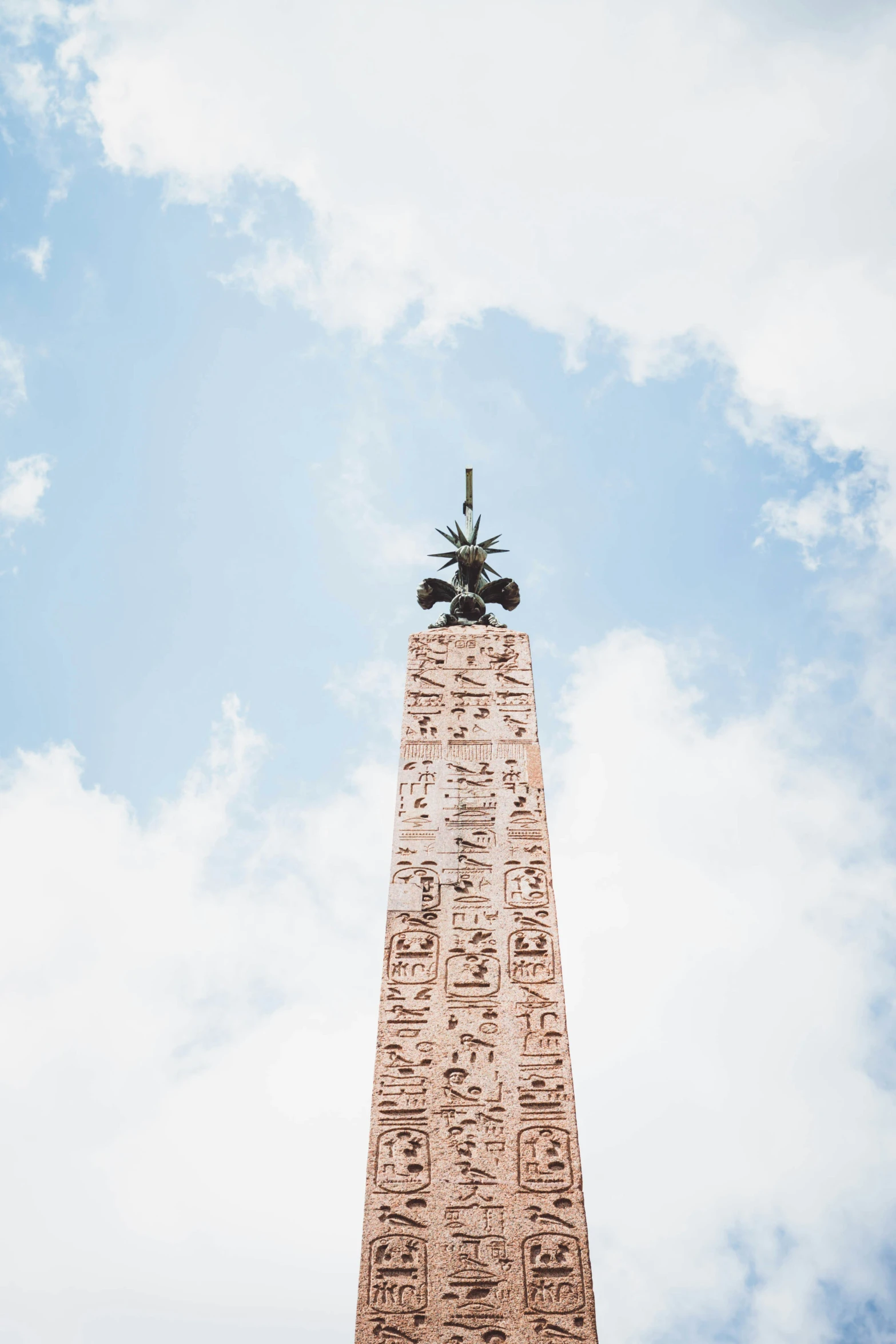 a statue is seen up high on a clock tower