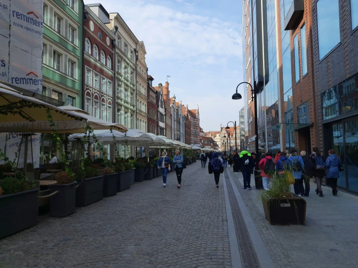 people walking down the street outside with open umbrellas