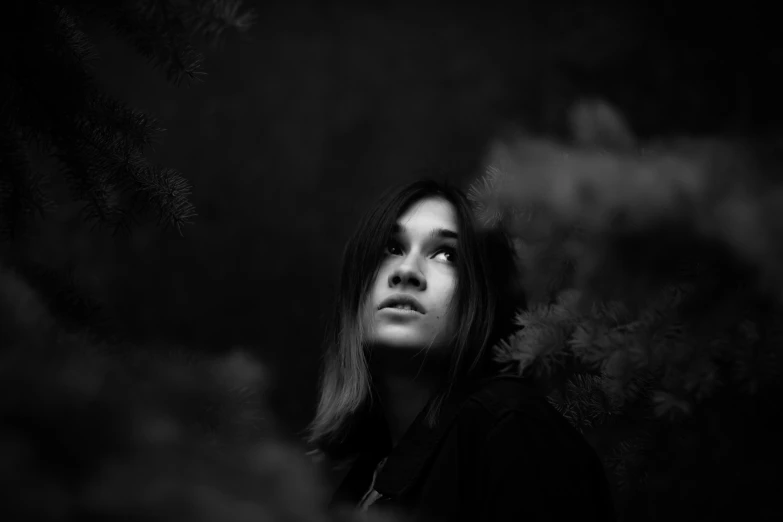 a person with long hair in front of a tree