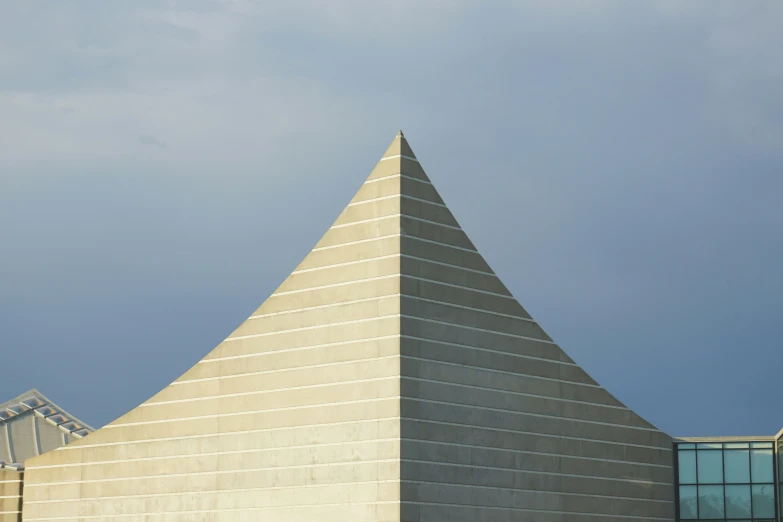 the triangular architecture of a modern building with a clock on the outside