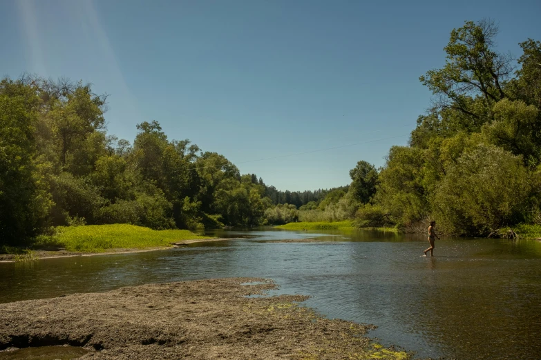 a man is wading in the middle of a river