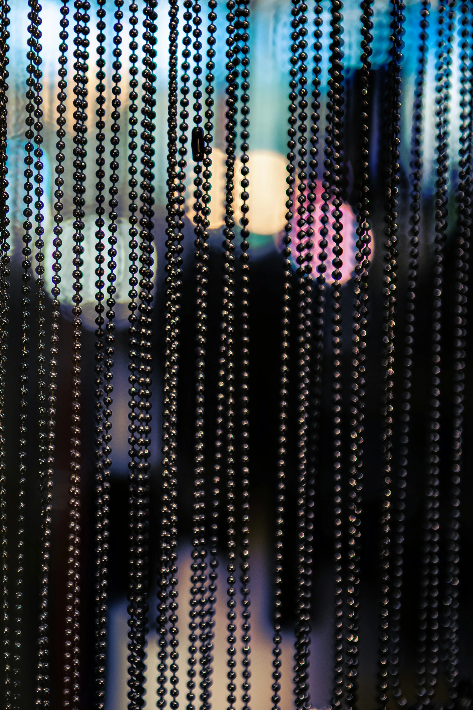 beads are hanging from the side of a glass window