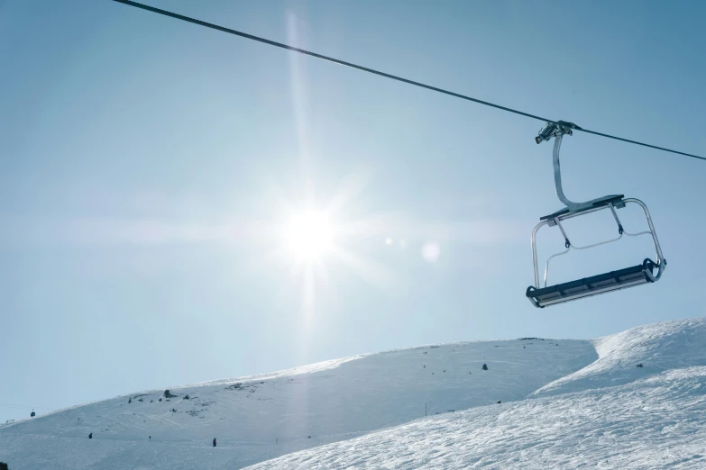 a ski lift and snow covered mountains are in the distance