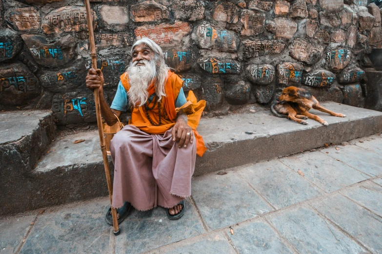 a man sitting next to his dog with a long beard