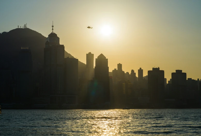 a boat traveling past the ocean in front of buildings