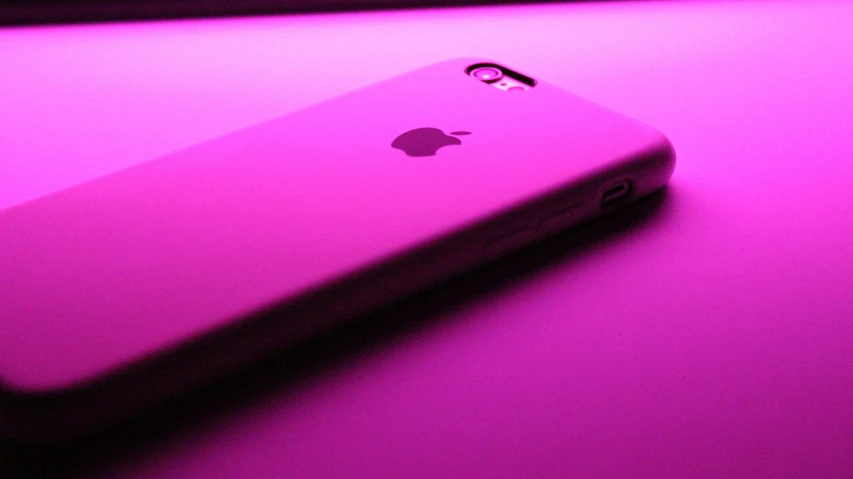 a pink phone sitting on top of a purple counter