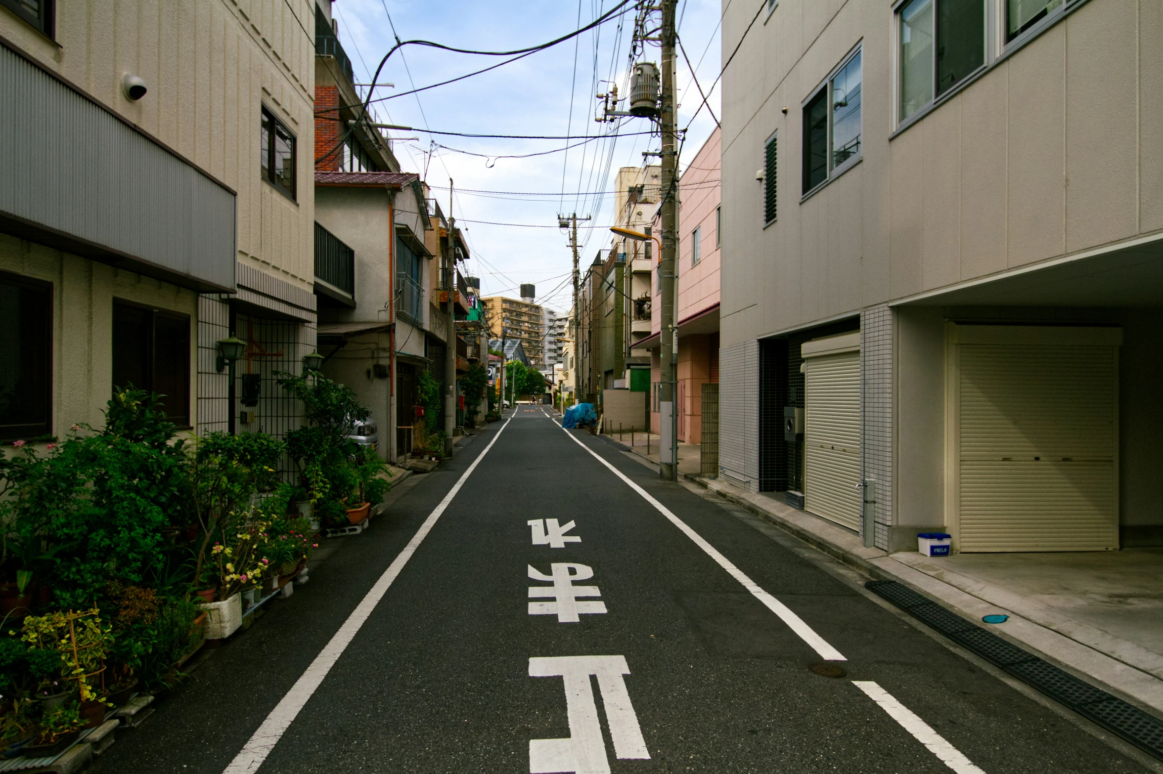 a narrow city street has two chinese characters painted on the lanes