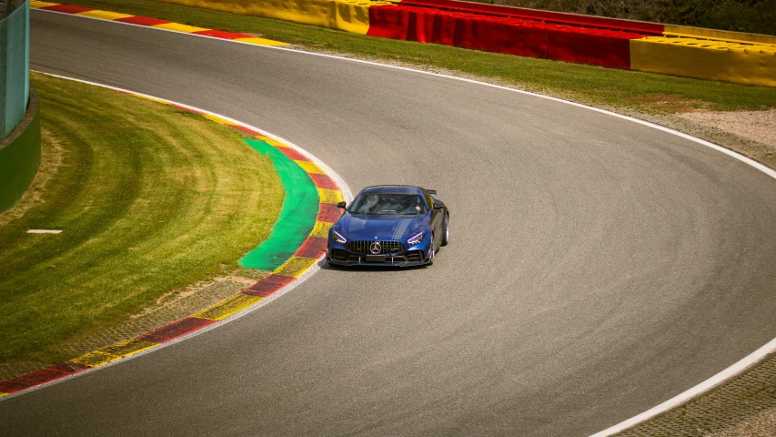 a bmw coupe driving on a road in front of grass