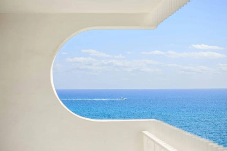 a view of the ocean from a room with an open window