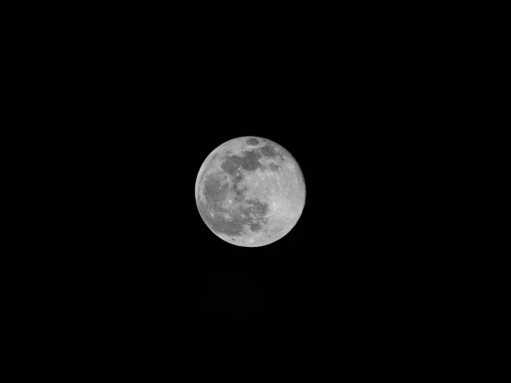 a large full moon with a dark sky background