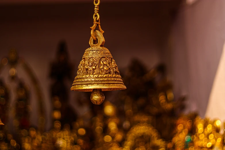 a bell hangs from a wall in front of several other statues
