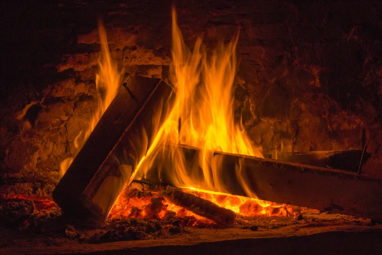 a fire blazing on a brick oven during the night