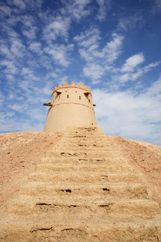 the top of a sand castle is shown with blue skies and clouds