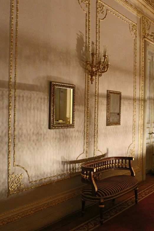 a room with a large chair, mirror and a chandelier