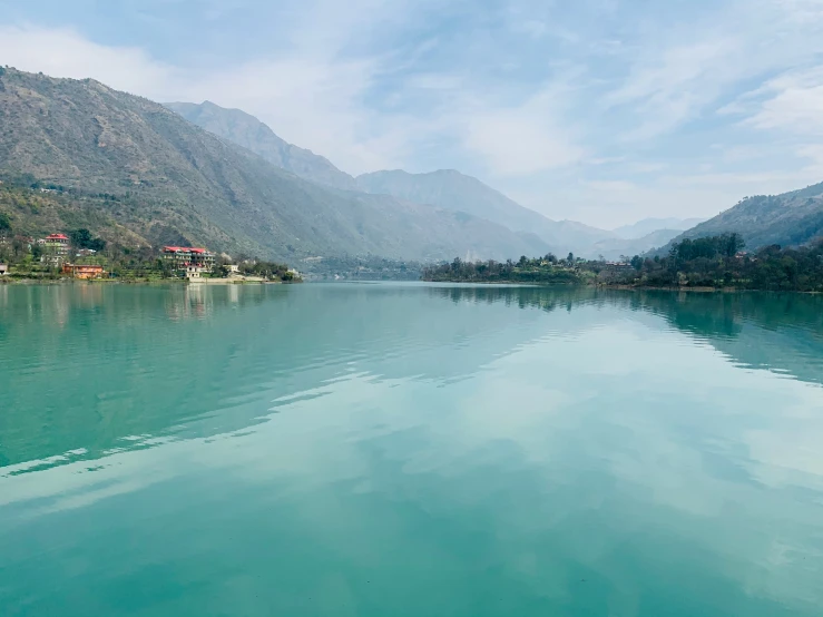 the water is calm, but there are mountains in the background