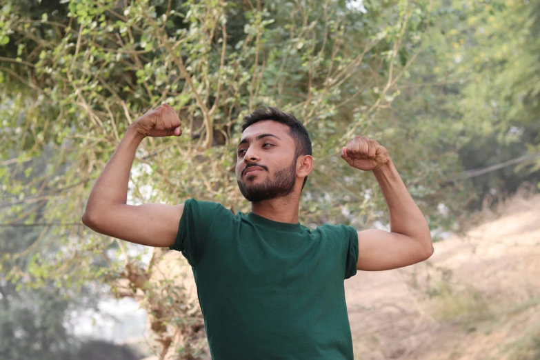 a man flexing his muscles on the side walk