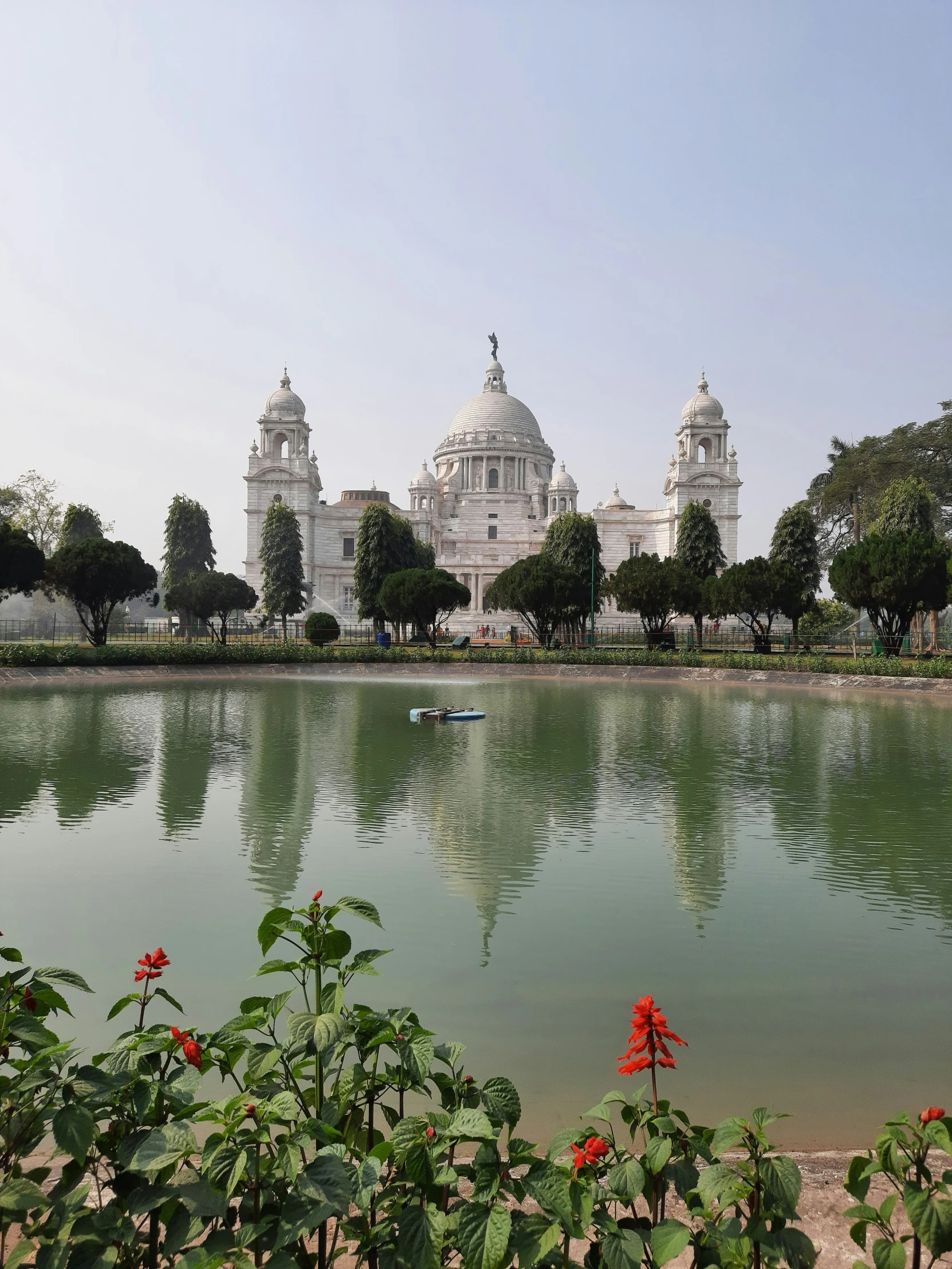 a pond sits below an impressive white building