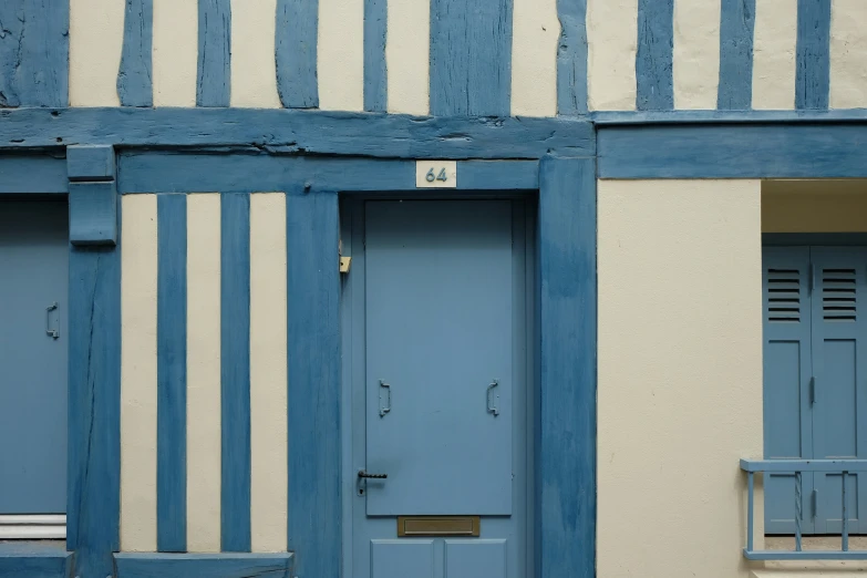 some blue doors in front of a white building