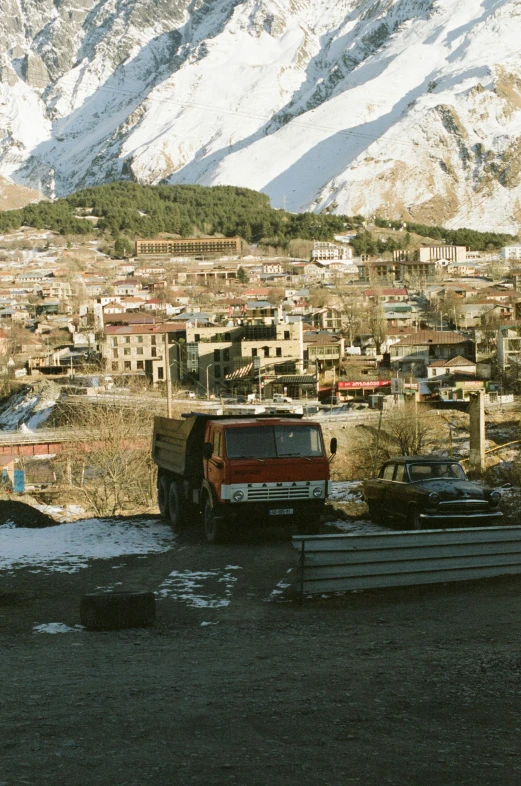 two trucks parked on top of a hill in front of some mountains