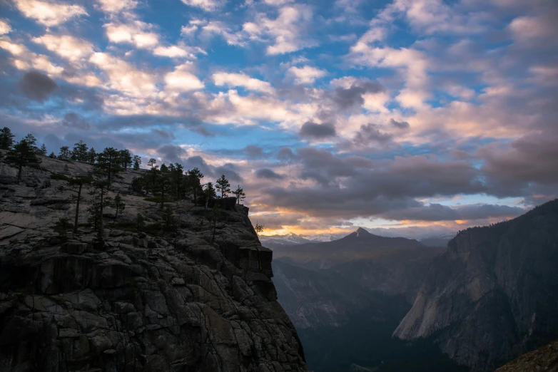 the sun sets over a valley with large rock formations