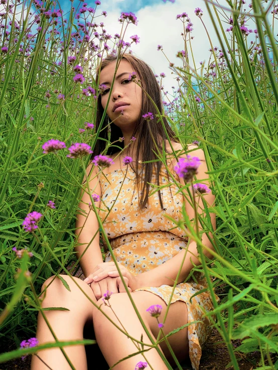 a woman sitting in a field of purple flowers