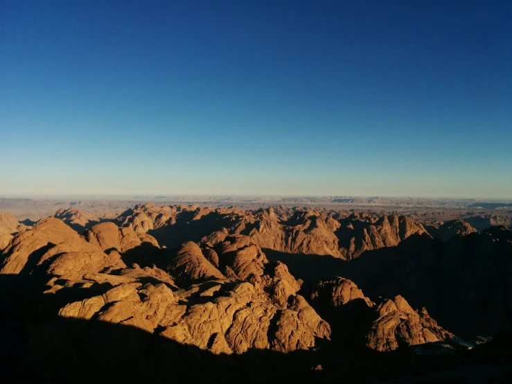 a valley is seen surrounded by mountains under a blue sky