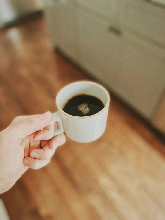 a person holding up a coffee cup