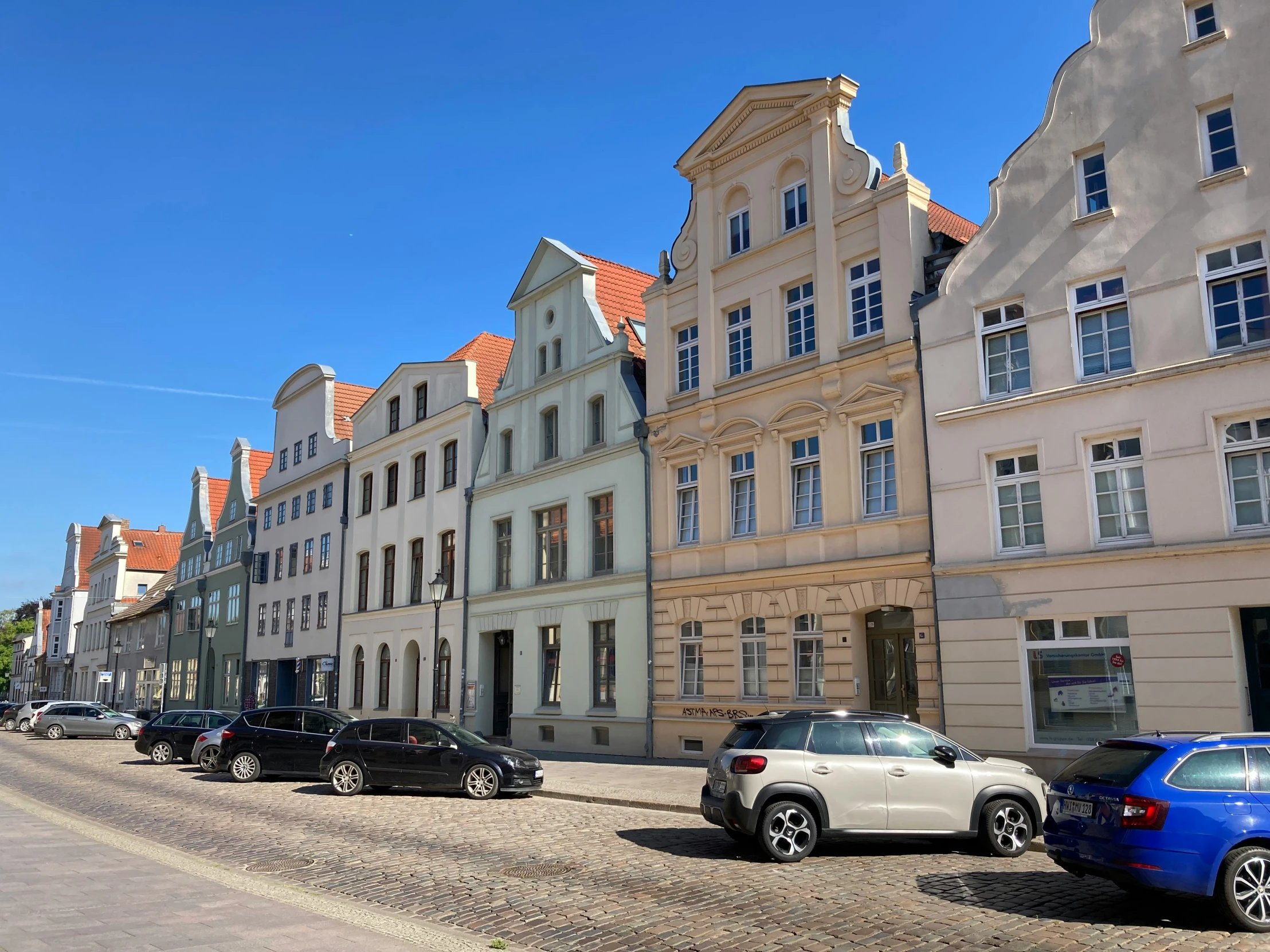 a street with cars parked in front of a large building